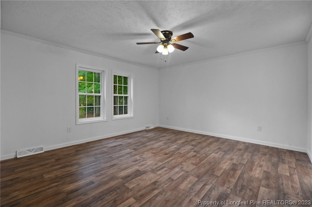 287 Doyle Cox Road Sanford, NC 27330 - Photo 6 of 35 a view of an empty room with wooden floor and a window