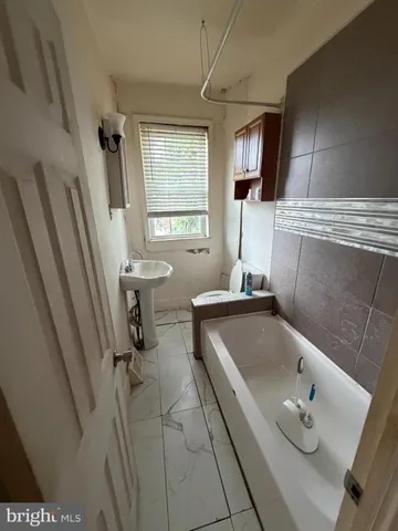 a bathroom with a tub a sink and a window