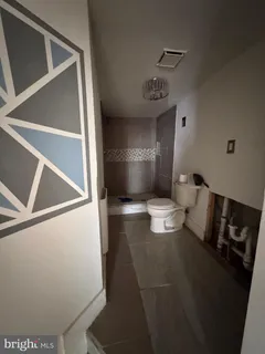 a bathroom with a toilet and a mirror