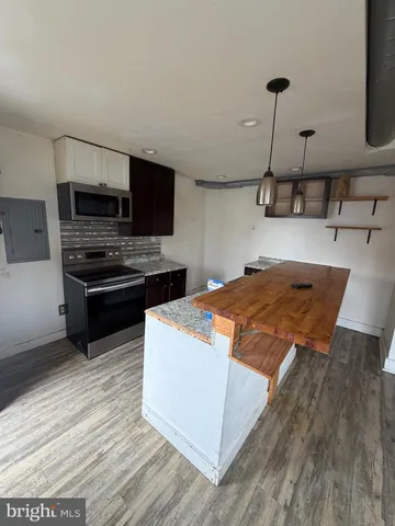 a kitchen with kitchen island a stove and a sink