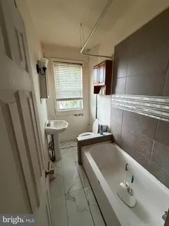 a bathroom with a sink a window and tub