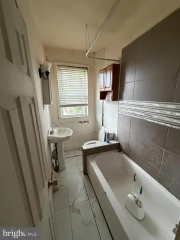a bathroom with a sink a window and tub