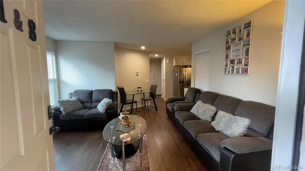 a living room with furniture and a wooden floor