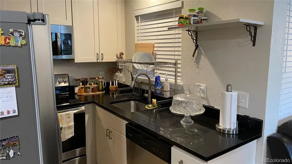 a kitchen with sink a refrigerator and cabinets