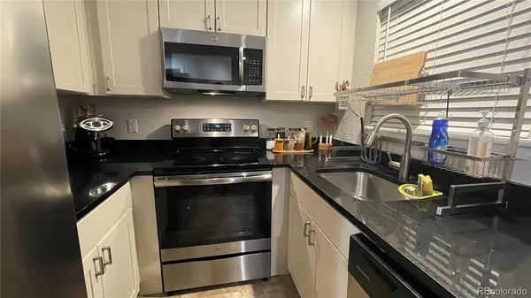 a kitchen with stainless steel appliances granite countertop a sink a stove and a microwave