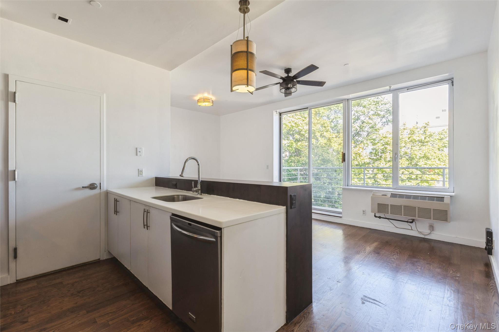 111 Monroe Street, Unit 4F Brooklyn, NY 11216 - Photo 6 of 25 Kitchen with an island, decorative light fixtures, wood floors, stainless steel appliances, and white cabinets