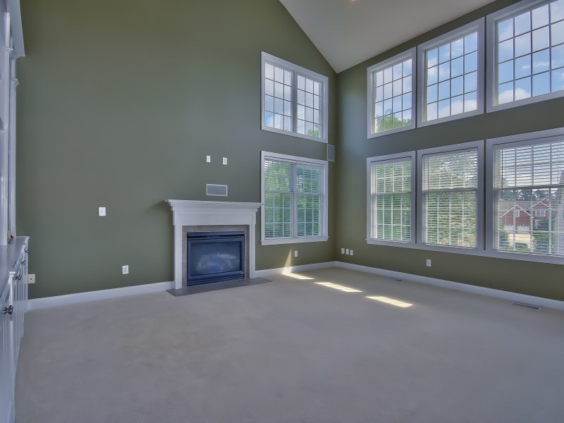 9612 Heathermill Lane Raleigh, NC 27617 - Photo 11 of 25 a view of an empty room with a fireplace and a window