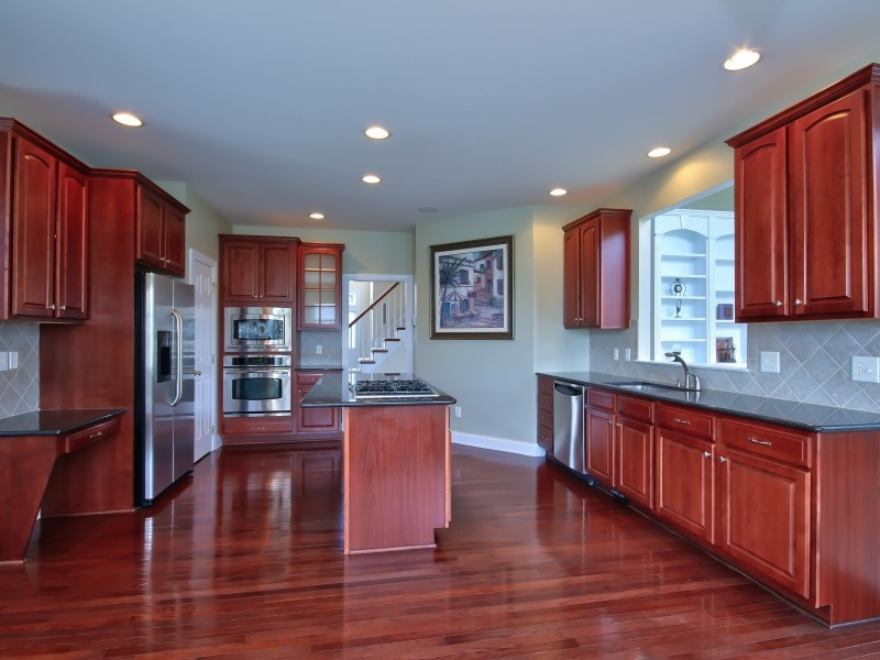 9612 Heathermill Lane Raleigh, NC 27617 - Photo 6 of 25 a open kitchen with stainless steel appliances granite countertop a refrigerator a sink dishwasher a stove and oven with wooden floor