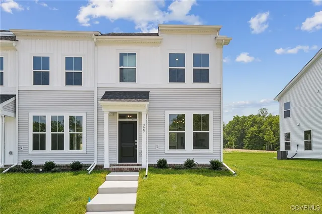a large tree in front of a brick house