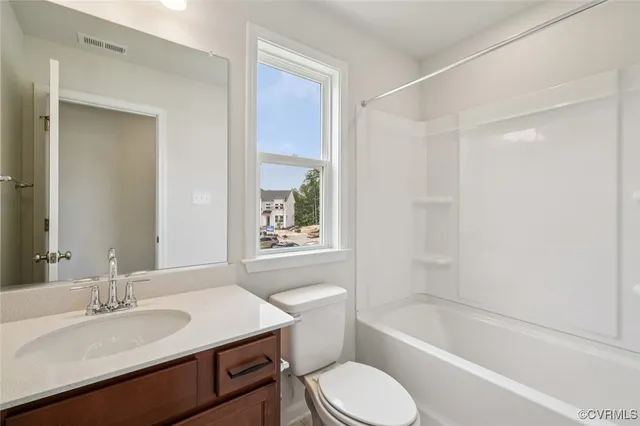 a bathroom with a granite countertop sink toilet a mirror and a bathtub