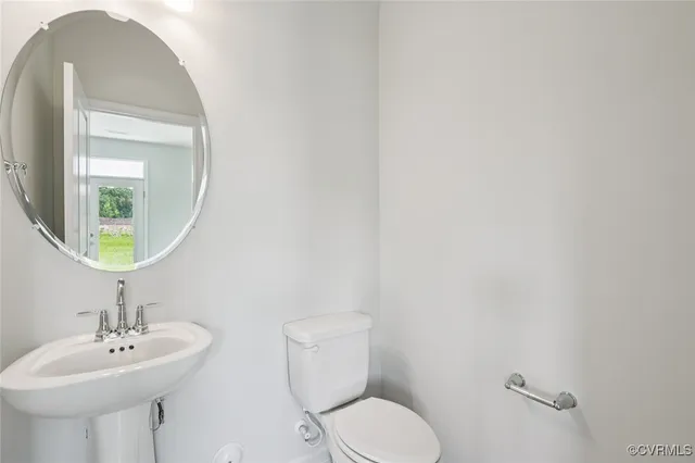 a bathroom with a toilet a sink and mirror