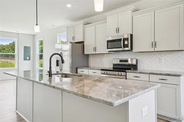 a kitchen with stainless steel appliances granite countertop a sink a microwave and cabinets