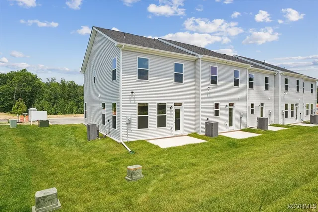 a large white house next to a yard with big trees