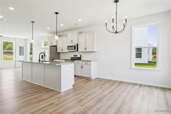 a kitchen with kitchen island white cabinets and black stainless steel appliances