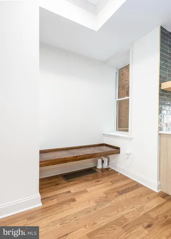 a kitchen with granite countertop a stove a sink and white cabinets