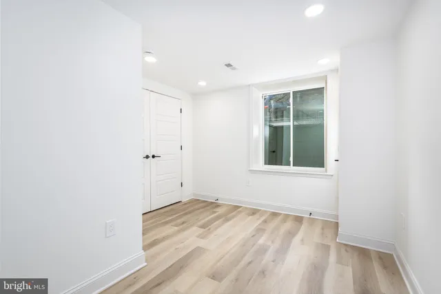 a view of empty room with wooden floor