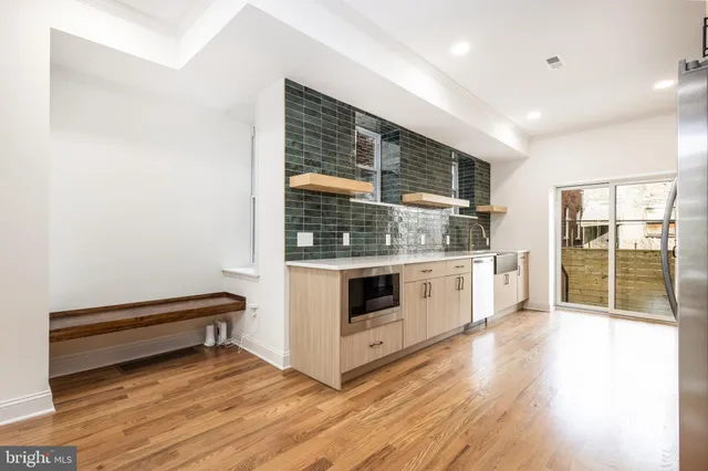 a kitchen with stainless steel appliances a stove and wooden floor