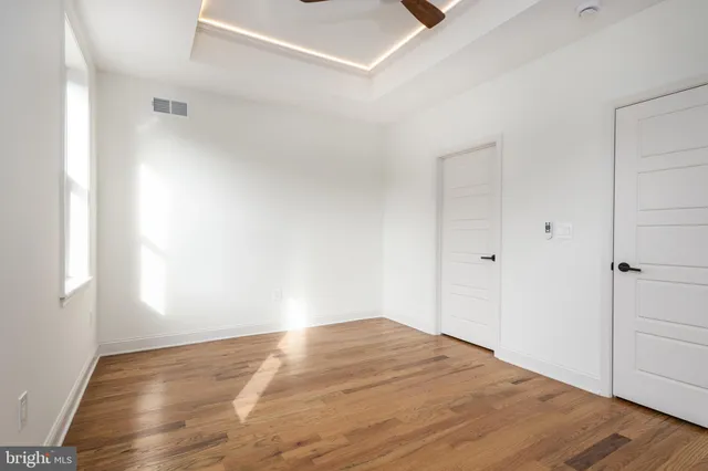 a view of empty room with wooden floor