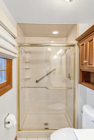 a bathroom with a toilet a sink and glass door