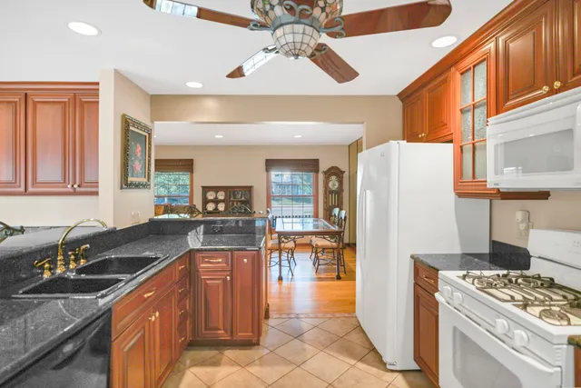 a kitchen with stainless steel appliances granite countertop a refrigerator a stove and a sink with cabinets