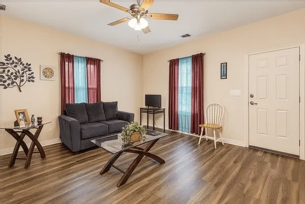 a living room with furniture and wooden floor