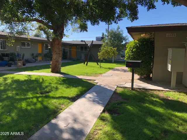a view of a house with backyard and a tree