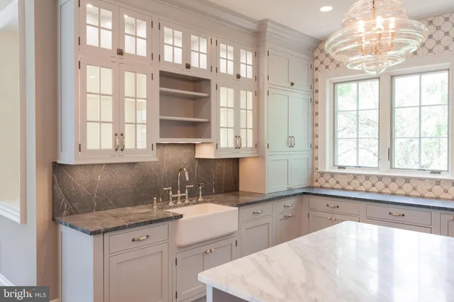 a kitchen with a stove a sink dishwasher and a dining table with wooden floor