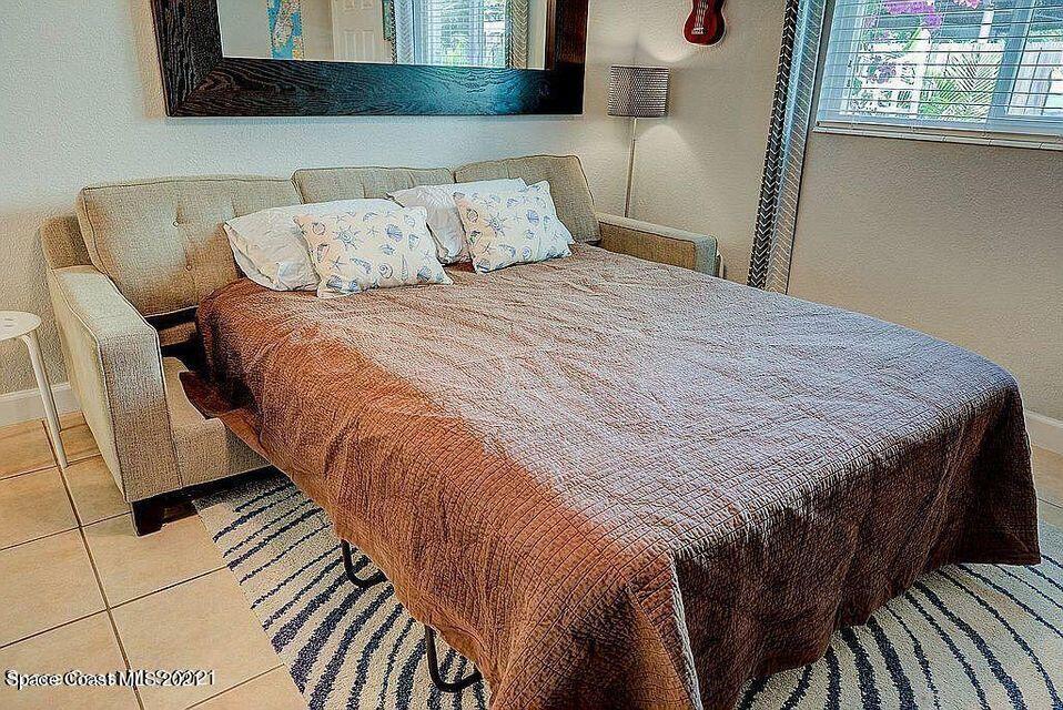 411 Audubon Drive Melbourne, FL 32901 - Photo 23 of 47 a bed sitting in a bedroom next to a window