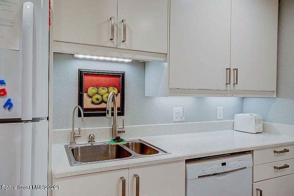 411 Audubon Drive Melbourne, FL 32901 - Photo 26 of 47 a kitchen with stainless steel appliances granite countertop a sink and a microwave