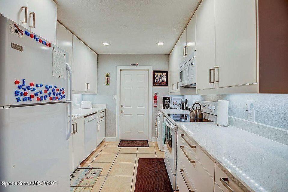 411 Audubon Drive Melbourne, FL 32901 - Photo 27 of 47 a kitchen with a sink stove and cabinets
