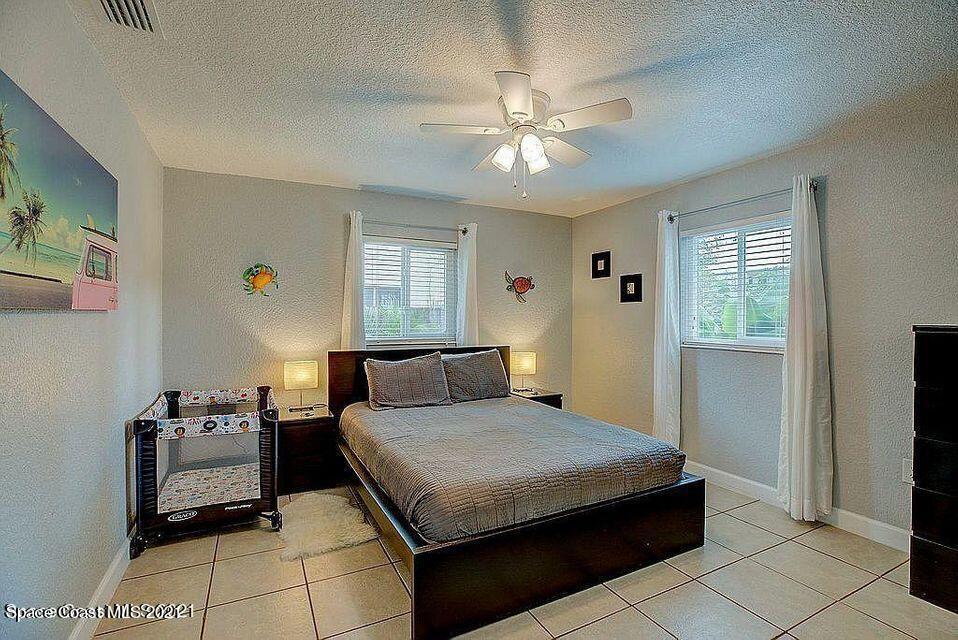 411 Audubon Drive Melbourne, FL 32901 - Photo 30 of 47 a bedroom with a bed and a chandelier