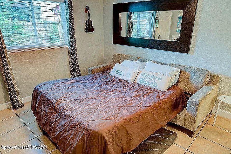 411 Audubon Drive Melbourne, FL 32901 - Photo 35 of 47 a bed sitting in a bedroom next to a window