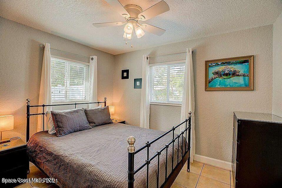 411 Audubon Drive Melbourne, FL 32901 - Photo 41 of 47 a bedroom with a bed and a chandelier