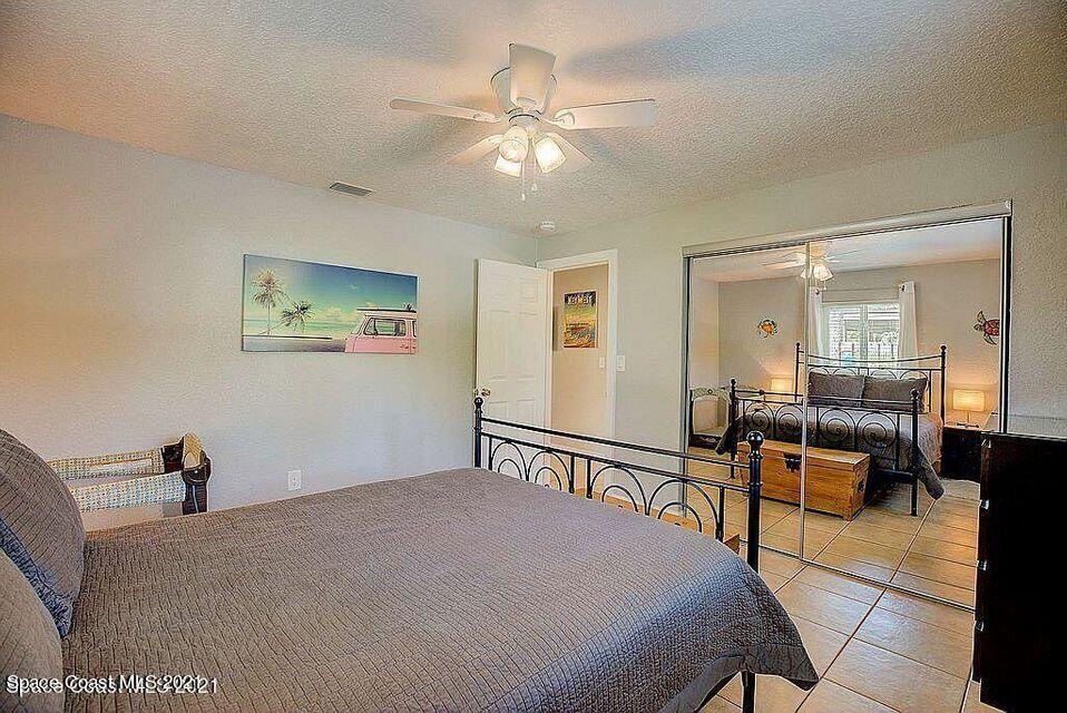 411 Audubon Drive Melbourne, FL 32901 - Photo 42 of 47 a bedroom with a bed and a chandelier