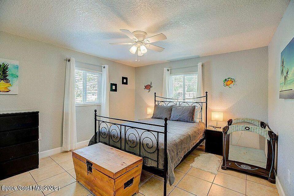 411 Audubon Drive Melbourne, FL 32901 - Photo 43 of 47 a bedroom with a bed and a chandelier