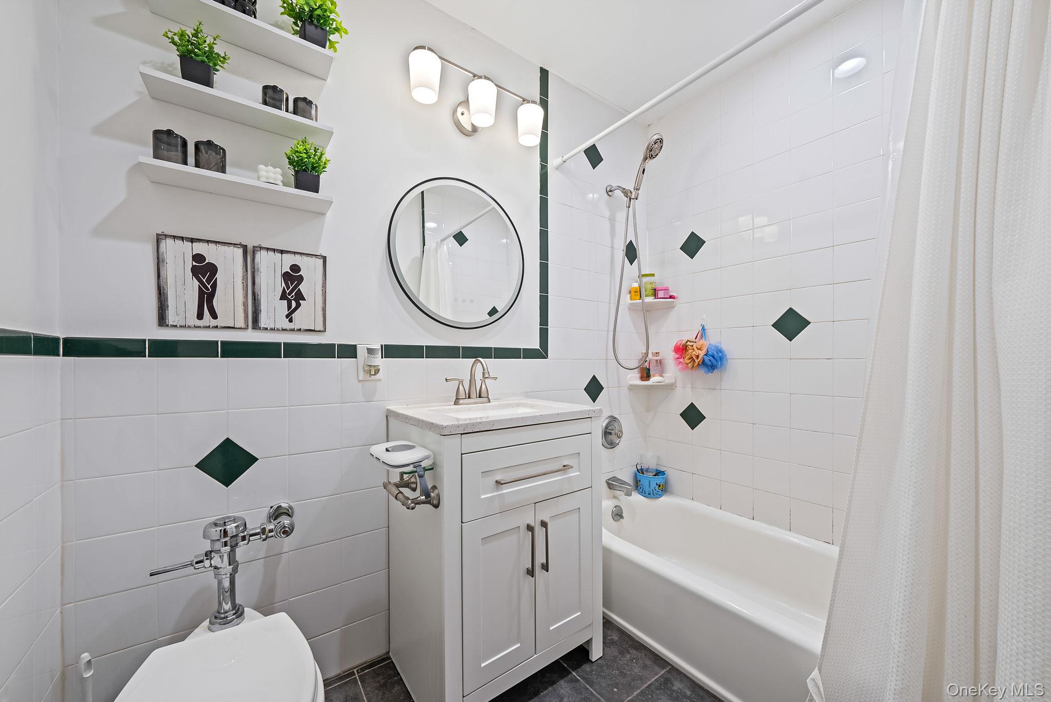 124 Smith Street, Unit 3F Freeport, NY 11520 - Photo 12 of 15 Bathroom featuring tile walls, vanity, shower / bath combo, and dark tile patterned floors