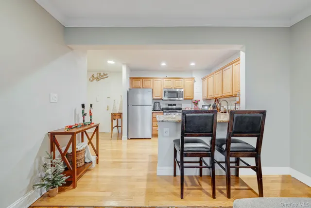 a kitchen with a refrigerator a stove and a dining table with wooden floor