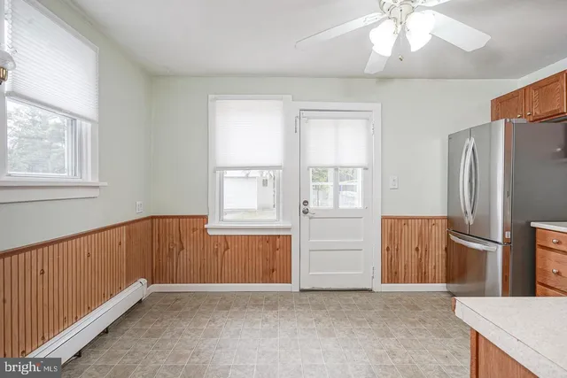 an empty room with windows cabinet and fire place