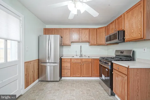 a kitchen with stainless steel appliances granite countertop a refrigerator stove top oven a sink and dishwasher