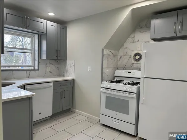 a kitchen with white cabinets and white appliances