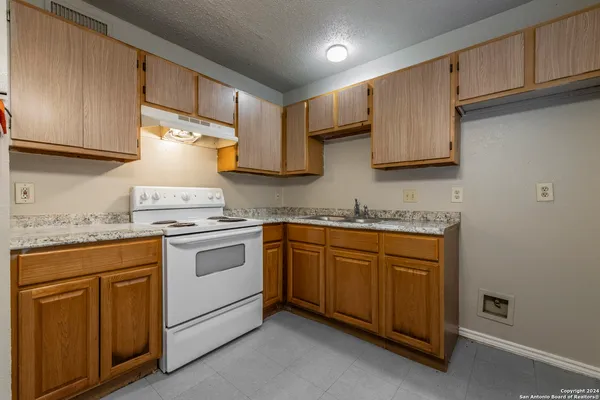 a kitchen with granite countertop white cabinets and white appliances