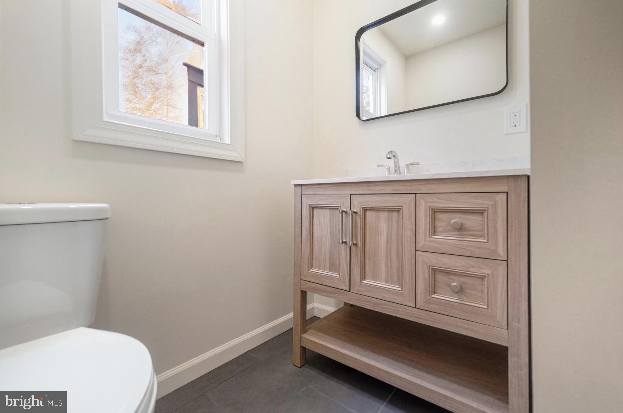 2446 46th Street Pennsauken, NJ 08110 - Photo 12 of 25 a bathroom with a toilet a sink and mirror