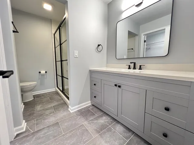 a spacious bathroom with a toilet sink and mirror