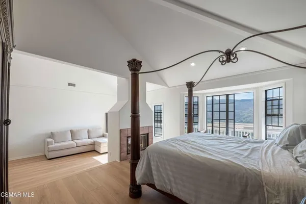 a bed sitting in a bedroom and a large window