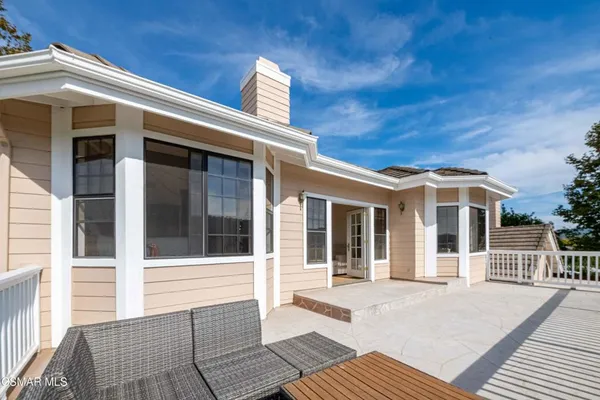 a view of a patio with a table chairs and a floor to ceiling window