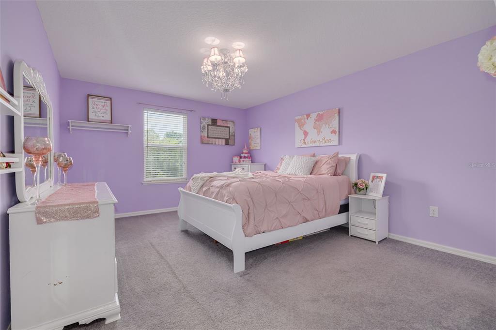 7242 Landmark Drive Spring Hill, FL 34606 - Photo 39 of 45 a bedroom with a bed and a chandelier