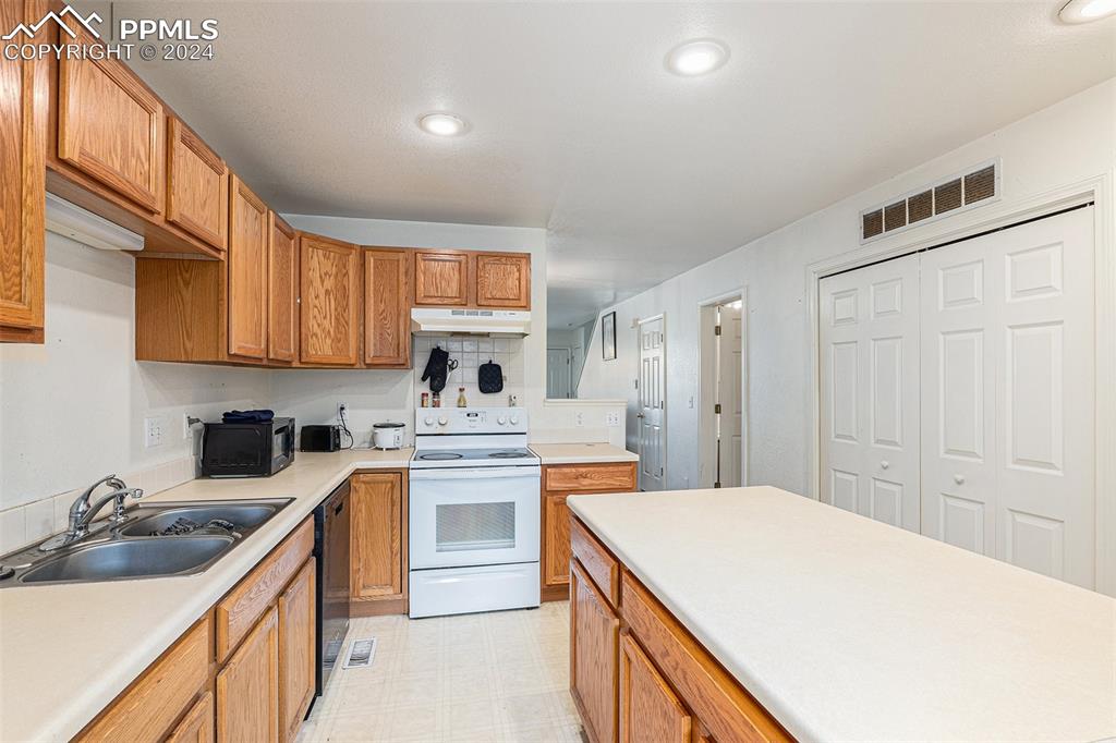 4400 Rawhide Road, Unit 159 Pueblo, CO 81008 - Photo 11 of 22 a kitchen with stainless steel appliances granite countertop a sink stove refrigerator and cabinets