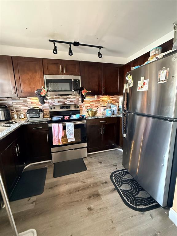 1805 Michigan Avenue, Unit D Kissimmee, FL 34744 - Photo 2 of 9 a kitchen with kitchen island granite countertop a sink stove and refrigerator