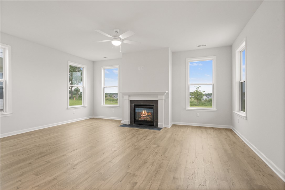 631 Sweetspire Trail, Unit 148 Seneca, SC 29678 - Photo 11 of 36 A well-lit living space features light-toned hardwood flooring and a cozy fireplace, perfect for gatherings.