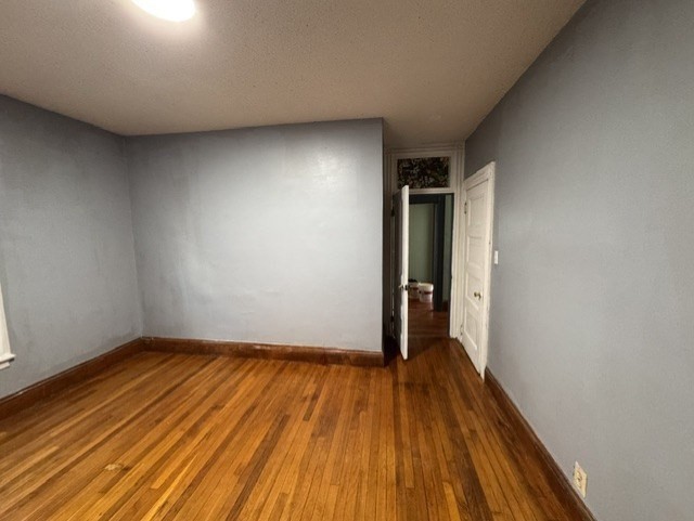 472 Warren Street Boston, MA 02121 - Photo 26 of 42 a view of an empty room with wooden floor and a ceiling fan
